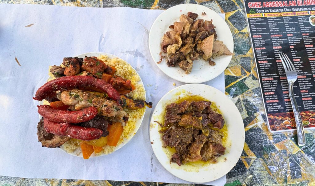 A traditional Moroccan meal featuring grilled meats, sausages, and couscous served at a local restaurant in Jemaa el-Fnaa, Marrakech.