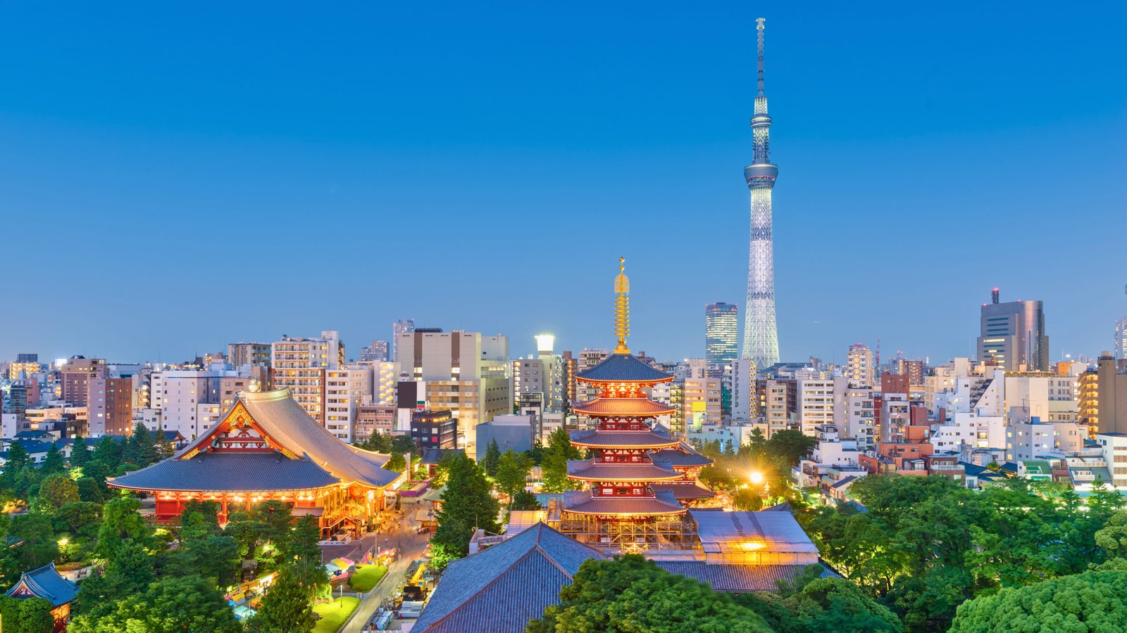 Tokyo skyline at dusk featuring the illuminated Senso-ji Temple and its five-story pagoda in Asakusa, with the towering Tokyo Skytree in the background, surrounded by a mix of modern and traditional architecture.